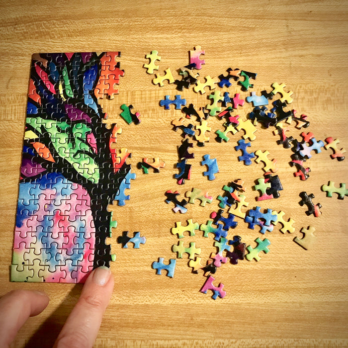 MicroPuzzle mini jigsaw puzzle being built from left to right colorful stained glass tree design